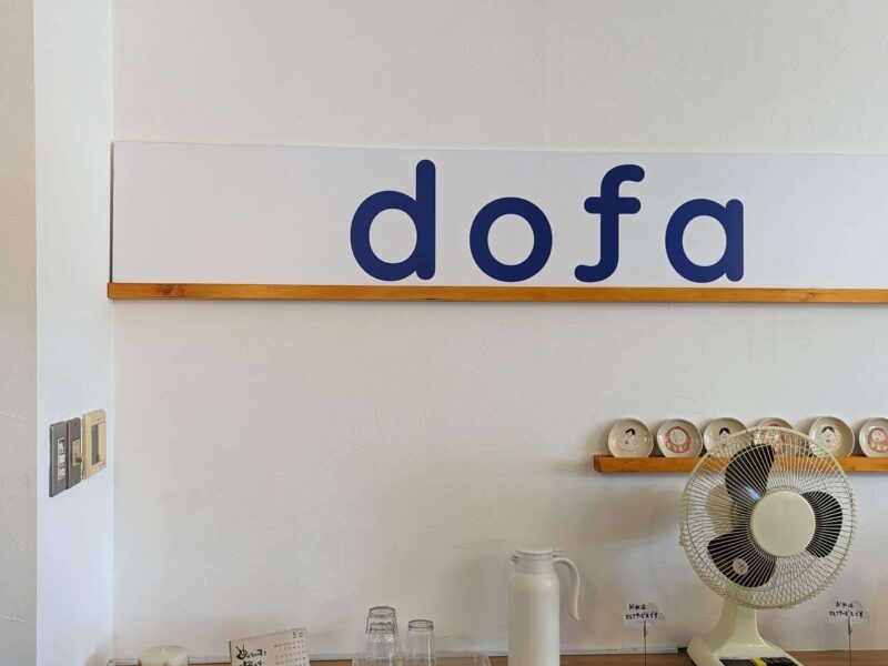 たむら食堂さんの壁に飾られた株式会社ドゥーファさんのロゴ